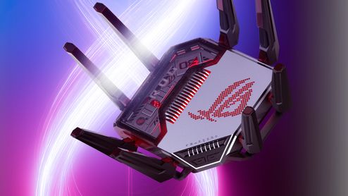 Router ASUS ROG Rapture GT-BN98 con múltiples antenas externas y logotipo iluminado sobre fondo abstracto.