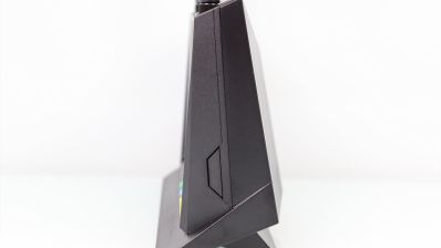 Vista de perfil de un router inalámbrico ASUS RT-AX86U de color negro sobre fondo blanco.
