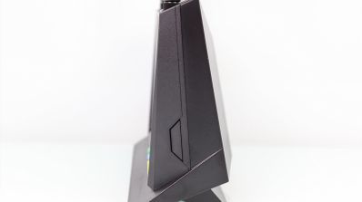Vista de perfil de un router inalámbrico ASUS RT-AX86U de color negro sobre fondo blanco.