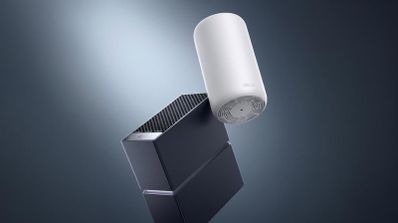 Dos dispositivos de red TP-Link Archer y Deco en color negro y blanco sobre un fondo oscuro con iluminación cenital.