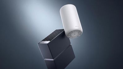 Dos dispositivos de red TP-Link Archer y Deco en color negro y blanco sobre un fondo oscuro con iluminación cenital.