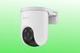 Cámara de seguridad EZVIZ de color blanco montada en soporte de pared sobre un fondo verde degradado.