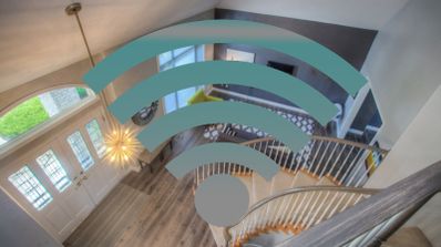 Icono de señal inalámbrica Wi-Fi superpuesto sobre el interior de una vivienda con escaleras y salón.