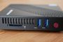 Panel frontal de un mini PC de color negro con puertos USB 3.0, lector de tarjetas SD y botón de encendido rojo.