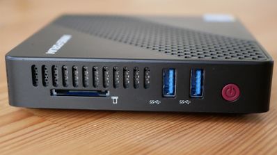Panel frontal de un mini PC de color negro con puertos USB 3.0, lector de tarjetas SD y botón de encendido rojo.