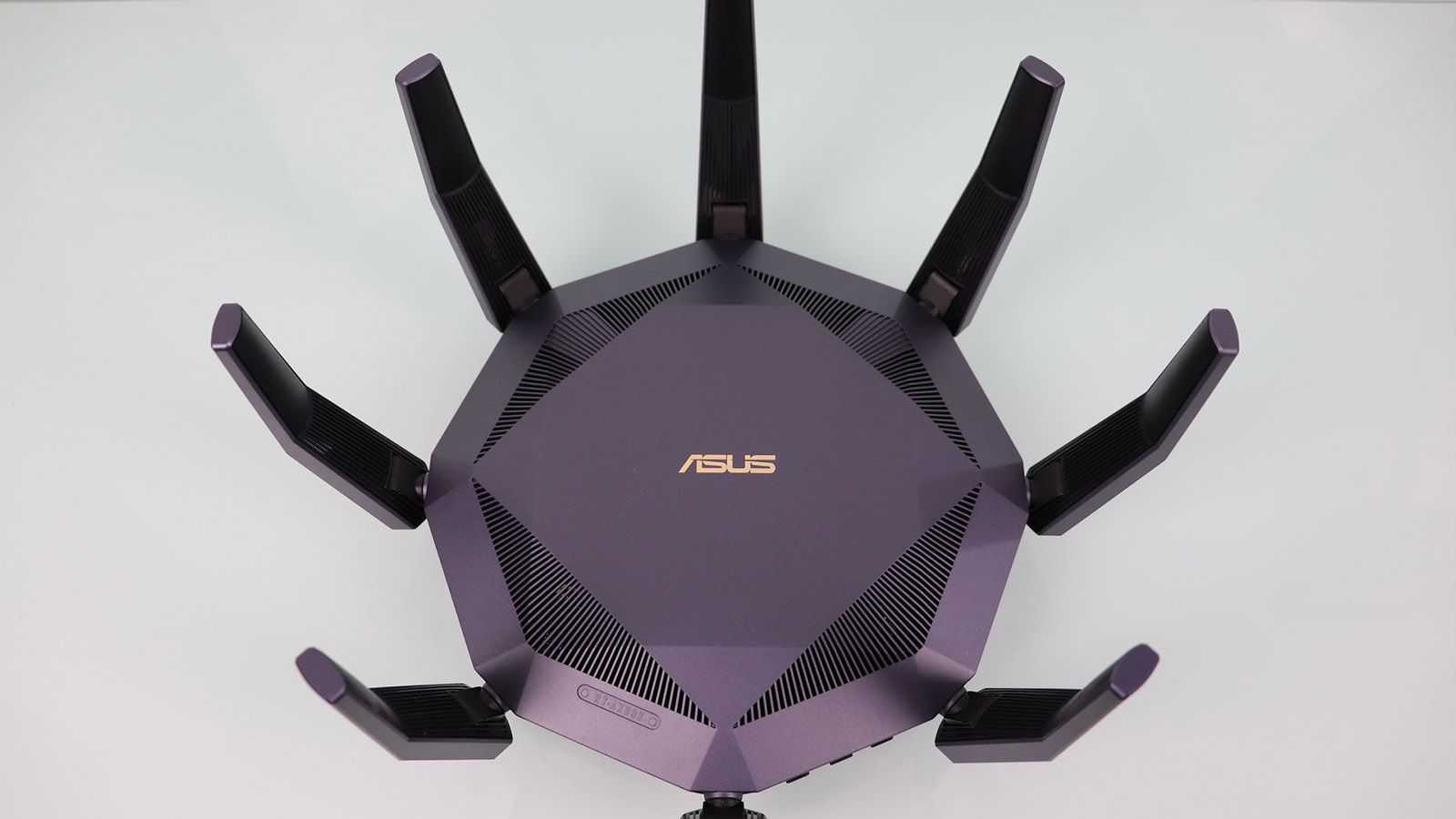 Vista cenital del router ASUS RT-AX89X con sus ocho antenas externas desplegadas en forma circular.