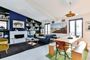 Salón comedor moderno con estantería integrada en la pared, chimenea, sofá azul y mesa de madera con bancos.