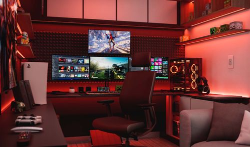 Habitación tipo setup gaming con varios monitores, torre de PC iluminada y consola, en un entorno con luces LED rojas.
