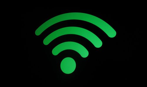 Icono de señal Wi-Fi de color verde sobre un fondo negro.