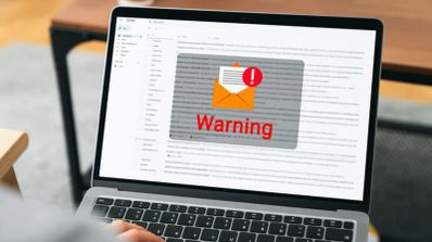 Pantalla de ordenador portátil mostrando un correo electrónico con un aviso de advertencia de seguridad superpuesto.