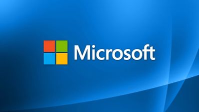 Logotipo de Microsoft con su símbolo de cuatro cuadrados de colores y nombre en blanco sobre un fondo azul con ondas degradadas.