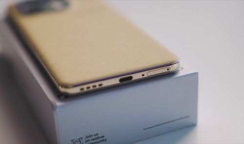 Detalle del borde inferior del realme 16 Pro mostrando el puerto USB-C y los altavoces sobre su caja.