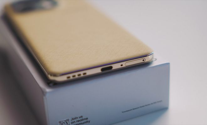 Detalle del borde inferior del realme 16 Pro mostrando el puerto USB-C y los altavoces sobre su caja.