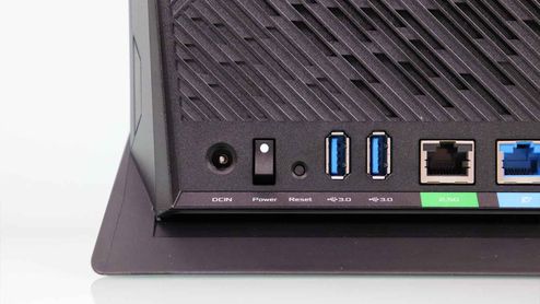 Detalle de los puertos traseros del router ASUS RT-AX86U que incluye tomas USB, botón de encendido y puertos Ethernet.