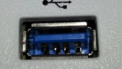 Primer plano de un puerto USB tipo A con el interior de color azul y el símbolo identificativo impreso encima.