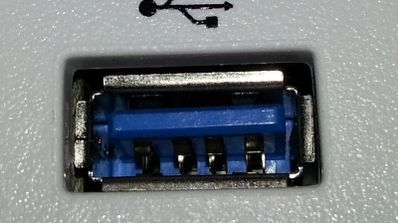 Primer plano de un puerto USB tipo A con el interior de color azul y el símbolo identificativo impreso encima.