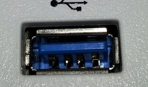 Primer plano de un puerto USB tipo A con el interior de color azul y el símbolo identificativo impreso encima.