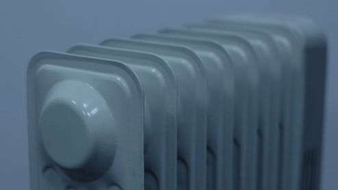Primer plano superior de los elementos de un radiador de pared metálico en color gris.