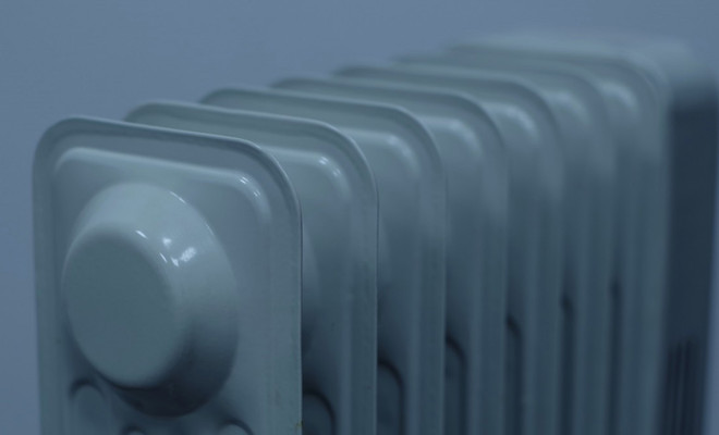 Primer plano superior de los elementos de un radiador de pared metálico en color gris.