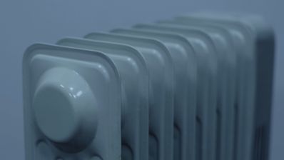 Primer plano superior de los elementos de un radiador de pared metálico en color gris.