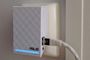 Repetidor Wi-Fi ASUS blanco con cable Ethernet conectado y luz LED azul encendida.