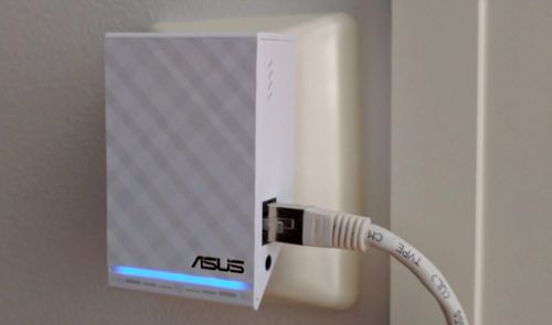 Repetidor Wi-Fi ASUS blanco con cable Ethernet conectado y luz LED azul encendida.