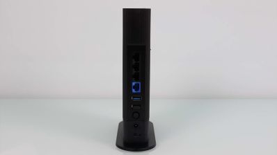 Panel trasero del router ASUS RT-AX59U mostrando sus puertos de conexión verticales sobre una base plana.
