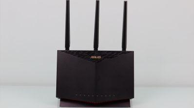 Router ASUS RT-AX86U visto de frente con sus tres antenas externas sobre un fondo blanco.