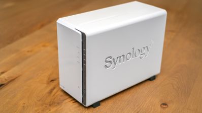 Servidor NAS Synology de color blanco sobre una superficie de madera.