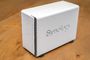 Servidor NAS Synology de color blanco sobre una superficie de madera.