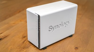 Servidor NAS Synology de color blanco sobre una superficie de madera.