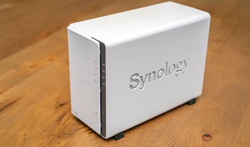 Servidor NAS Synology de color blanco sobre una superficie de madera.