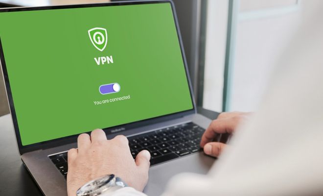 Persona utilizando un ordenador portátil con una aplicación de VPN conectada en pantalla.