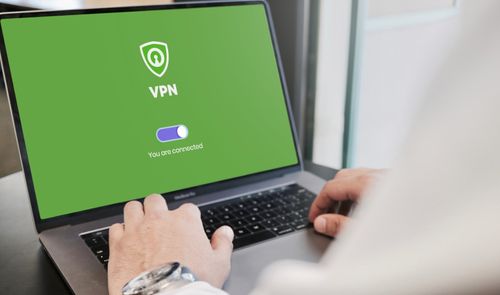 Persona utilizando un ordenador portátil con una aplicación de VPN conectada en pantalla.