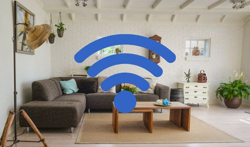 Icono de señal inalámbrica azul superpuesto sobre el salón de una vivienda con sofás y muebles de madera.