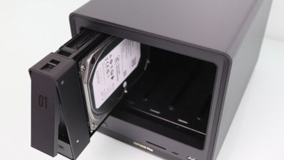 Primer plano de la inserción de un disco duro mecánico en la bahía número uno de un servidor NAS.
