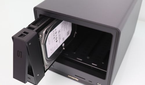 Primer plano de la inserción de un disco duro mecánico en la bahía número uno de un servidor NAS.