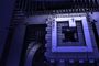 Primer plano de la arquitectura interna de un procesador para PC cuántico con iluminación en tonos azules y sombras profundas.