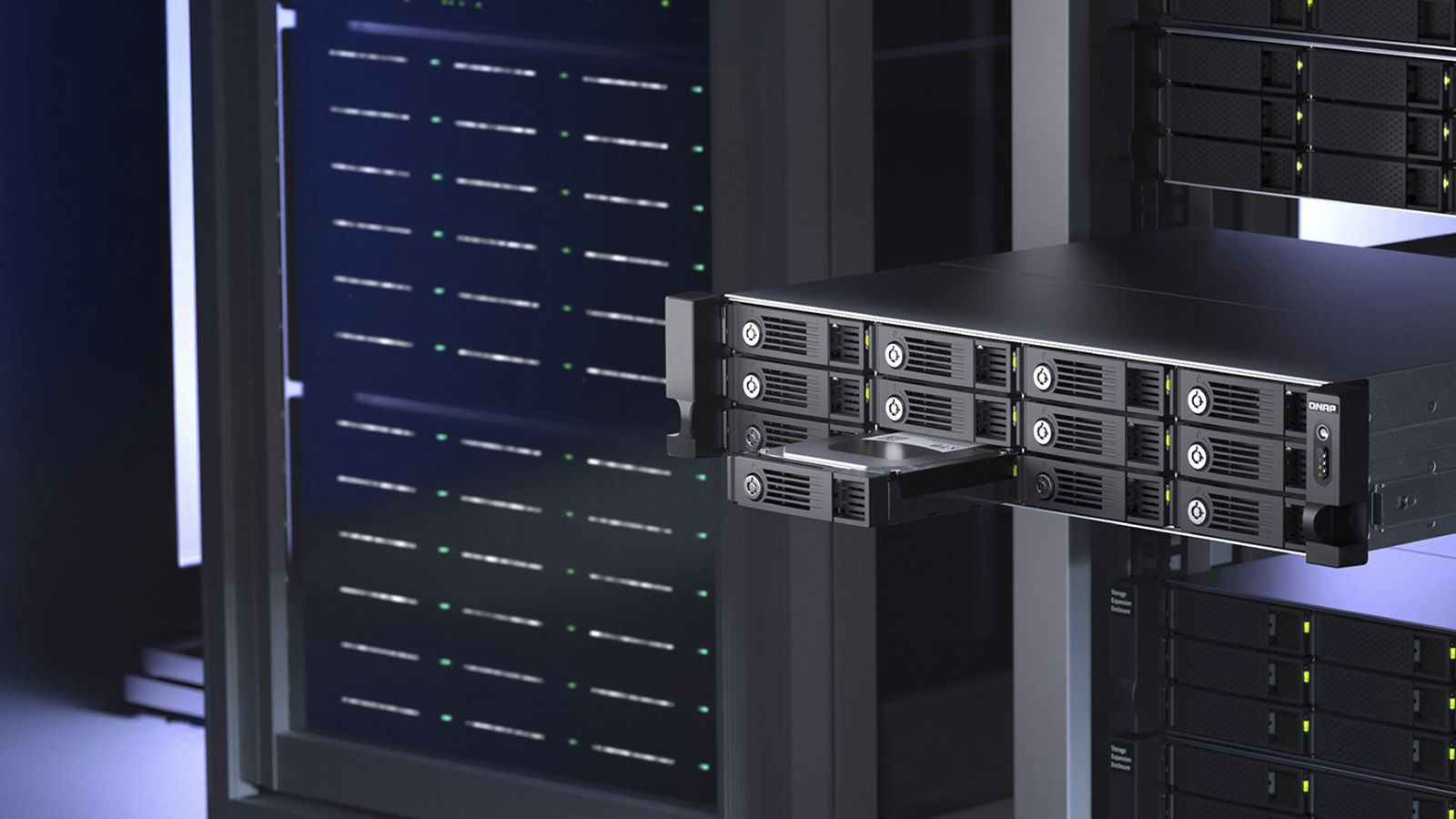 Unidad de almacenamiento QNAP TL-R1210TC4 instalada en un rack con una de sus doce bahías frontales extraída.