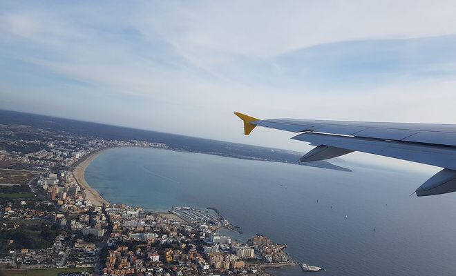 Vista aérea desde la ventanilla de un avión de Vueling sobrevolando la costa de Palma de Mallorca.