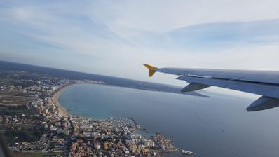 Vista aérea desde la ventanilla de un avión de Vueling sobrevolando la costa de Palma de Mallorca.