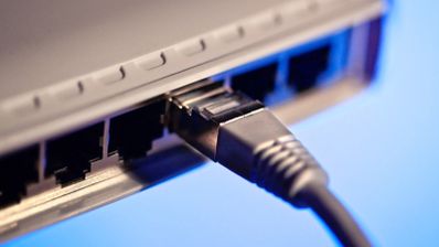 Primer plano de un conector RJ45 introducido en el puerto de red de un switch.