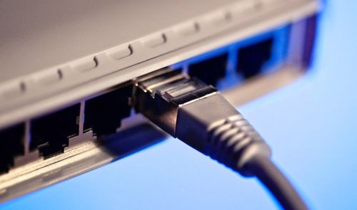 Primer plano de un conector RJ45 introducido en el puerto de red de un switch.
