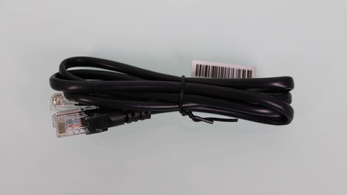Cable Ethernet negro enrollado con conectores RJ45 y etiqueta de código de barras sobre un fondo claro.