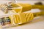 Dos conectores RJ45 de cables Ethernet amarillos vistos de cerca.