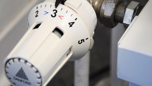 Primer plano de una válvula termostática de radiador Danfoss con el dial ajustado en el número tres.