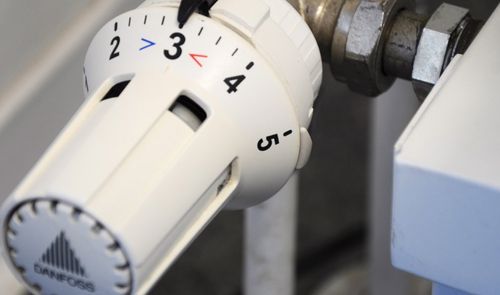 Primer plano de una válvula termostática de radiador Danfoss con el dial ajustado en el número tres.