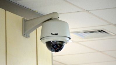 Cámara de seguridad domo de la marca Dahua instalada en el soporte de una pared interior.