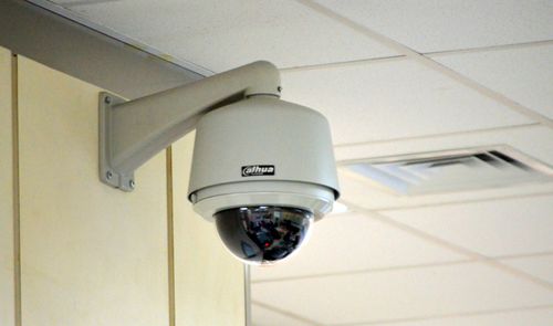 Cámara de seguridad domo de la marca Dahua instalada en el soporte de una pared interior.
