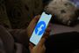 Persona sosteniendo un teléfono móvil con el logotipo de Facebook en pantalla.